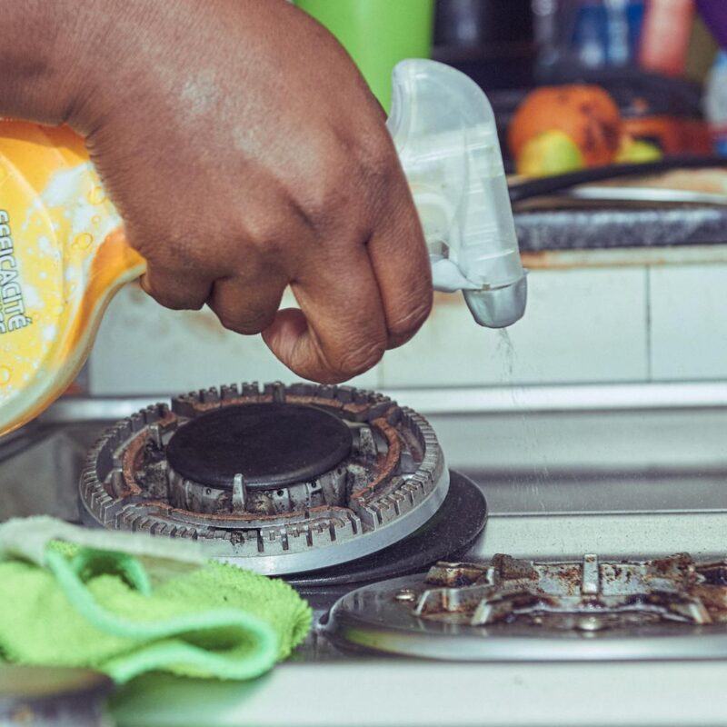 Person Cleaning a Gas Stove