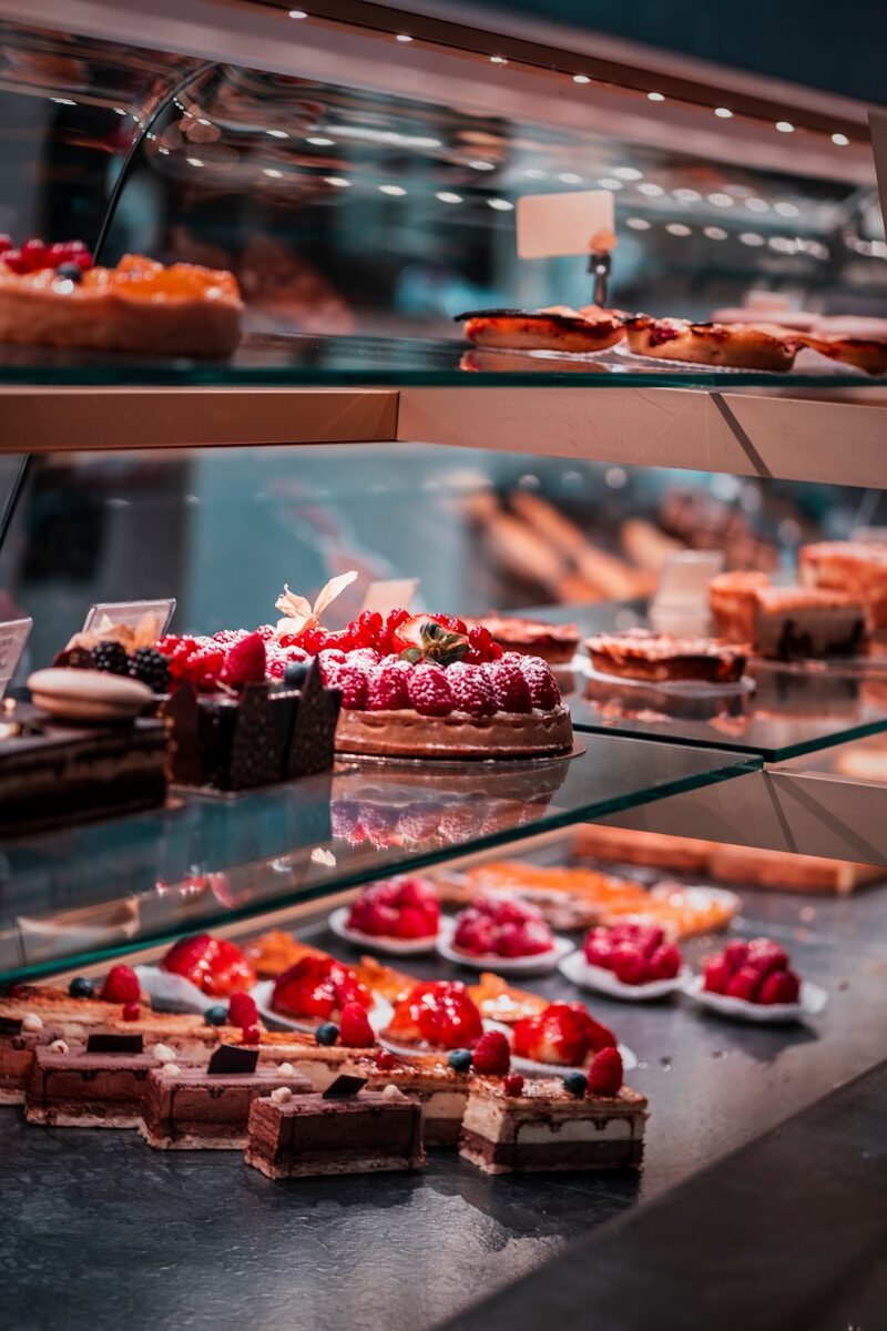 strawberry and blackberry on clear glass display counter