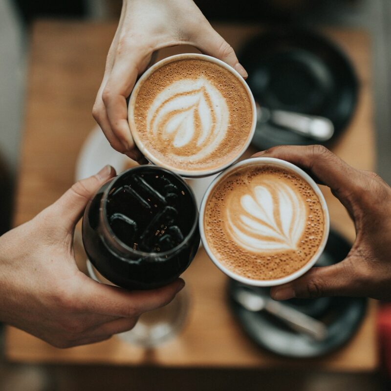 three person holding beverage cups