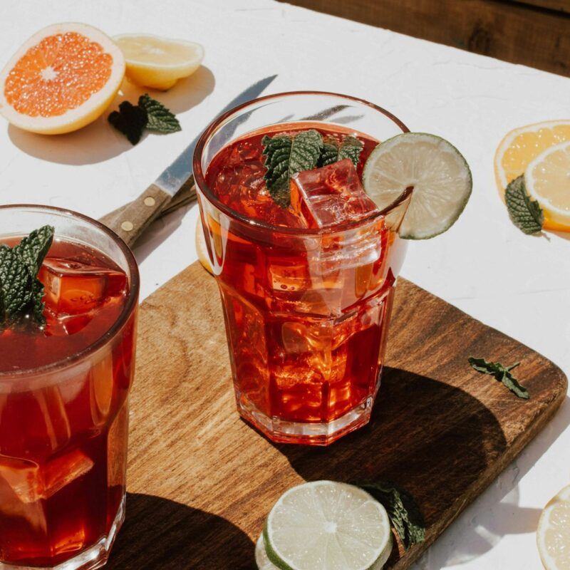 two clear drinking glasses with filled red liquid