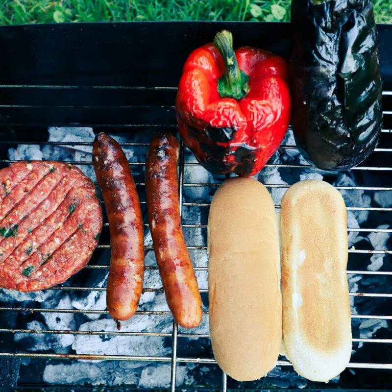 sausages and a strawberry on a grill