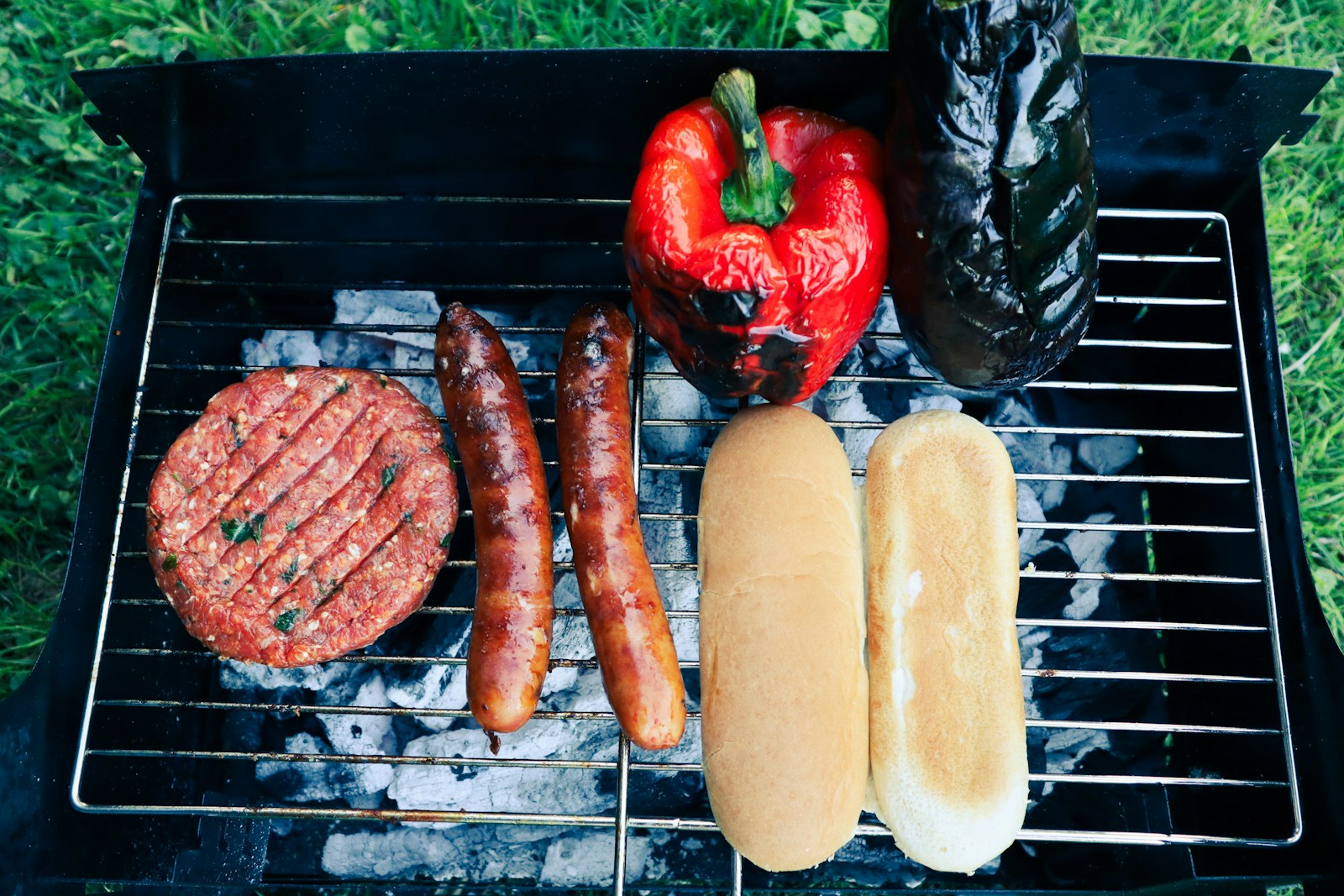 sausages and a strawberry on a grill